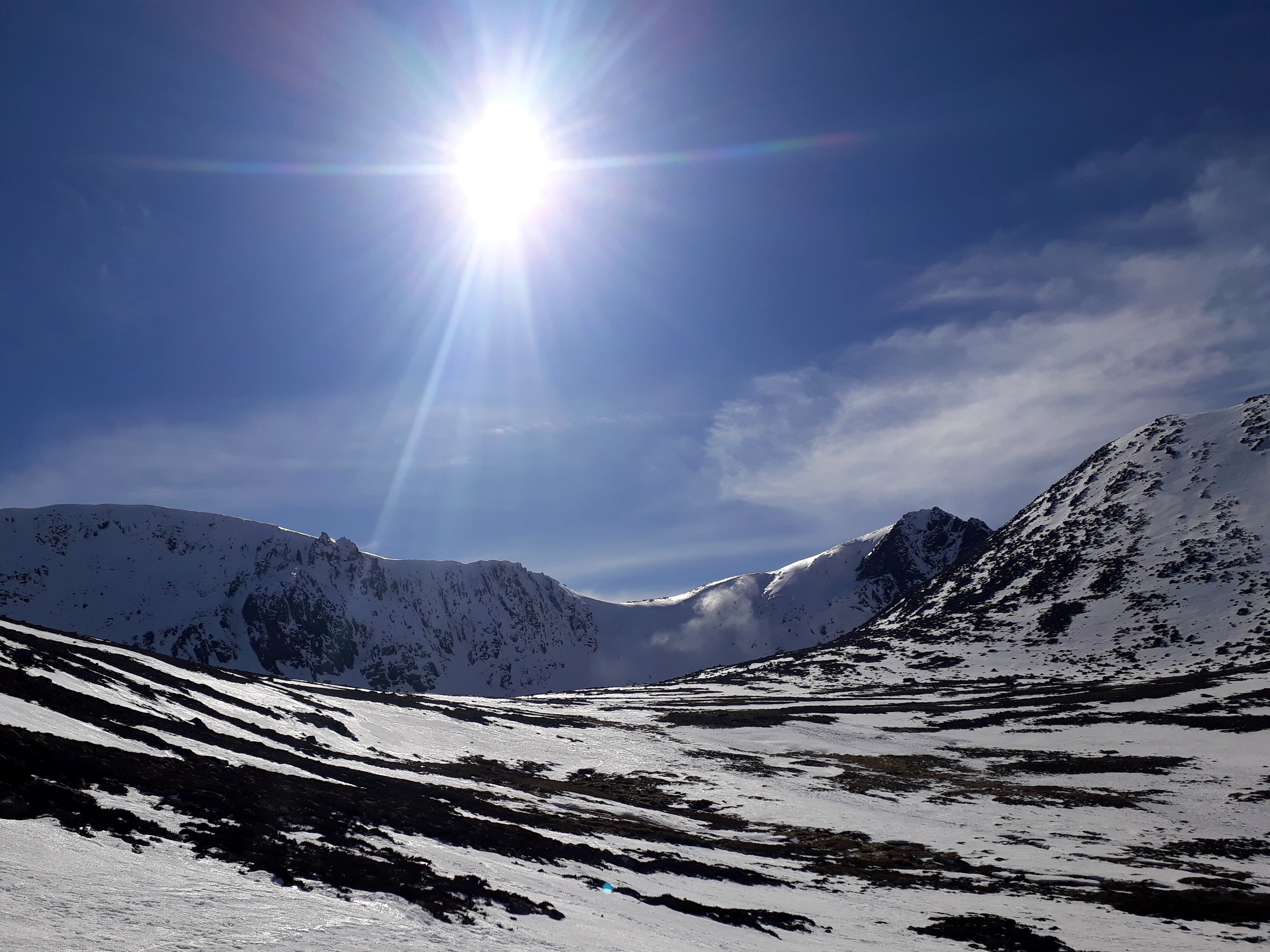 Coire an t-Sneachda on 19th March 2022 showing blue skies and spin drift